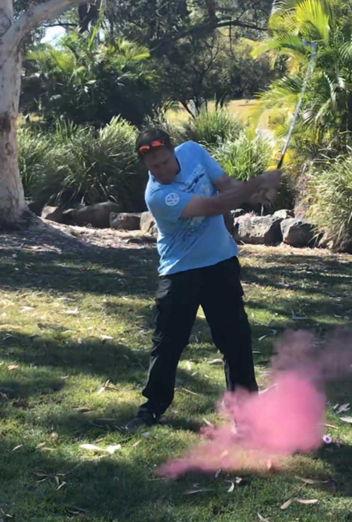 Dad hitting Gender Reveal Golf Ball, pink gender reveal